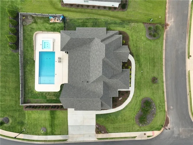 An aerial perspective reveals a private pool with an adjacent spa, set within a manicured backyard.
