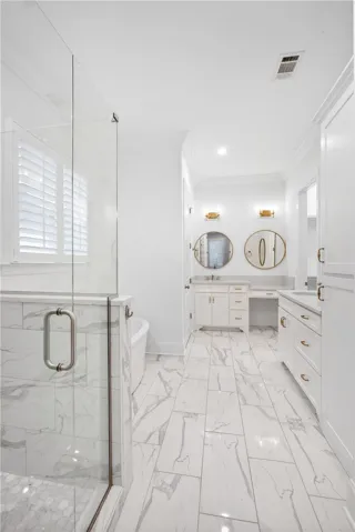 Luxurious tile flooring and contemporary fixtures define this elegant bathroom retreat.