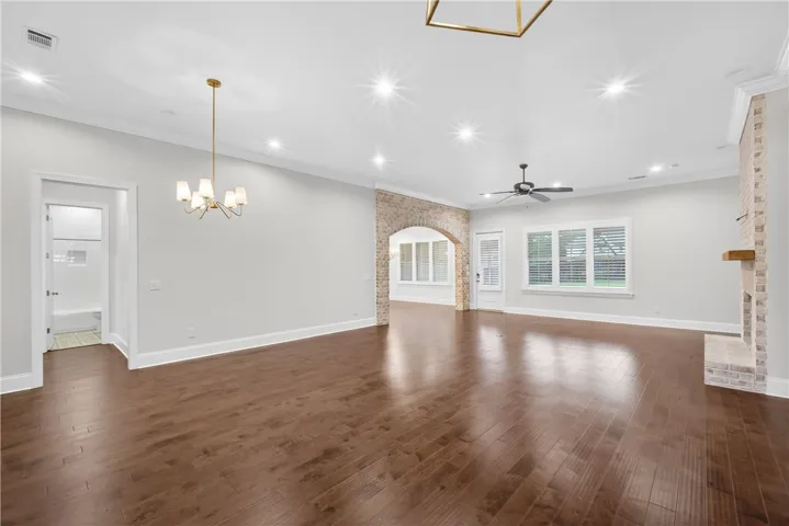 Rich hardwood floors flow through this spacious living area, complete with a cozy fireplace and inviting archways.