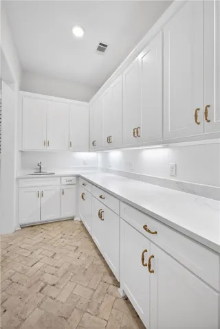 White cabinetry with ornate hardware and ample counter space define this functional utility area.