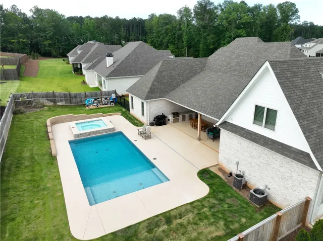An inviting backyard oasis offers a sparkling pool and spa, perfect for recreation and relaxation.