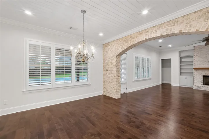 Warm hardwood floors and an elegant chandelier complement this inviting living space.