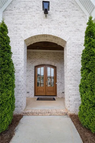An inviting entry showcases an arched brick façade and handsome wood doors.