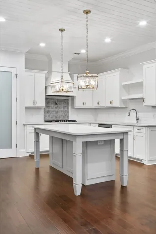 A well-appointed kitchen features a central island, rich wood floors, and modern fixtures.