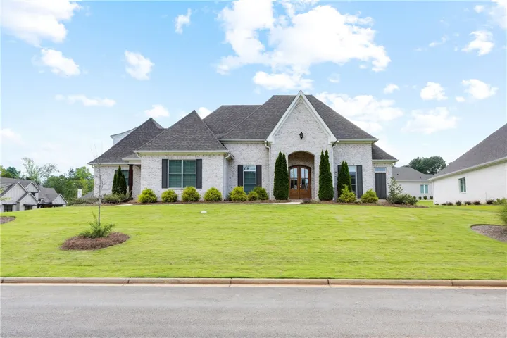A handsome residence with a pristine lawn and elegant double entry doors awaits.