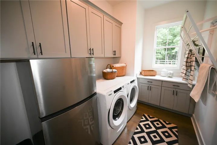 Laundry with tons of cabinetry, drying racks, folding space, & room for a second fridge!
