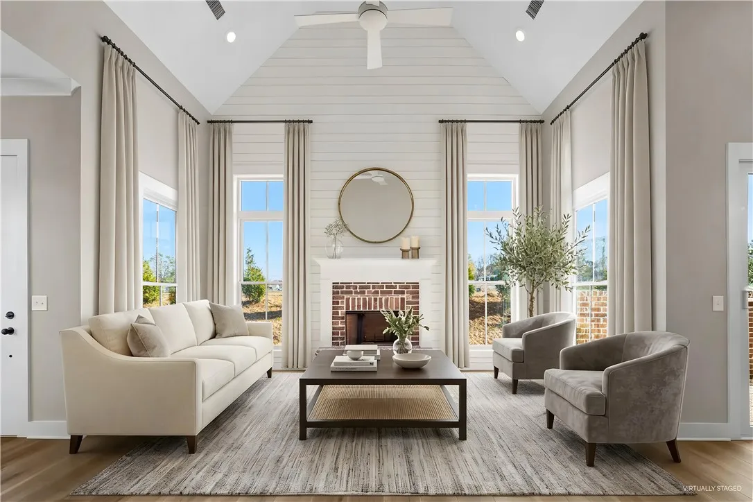 This airy living room features high ceilings and a cozy fireplace, perfect for relaxation and gatherings. (virtually staged)