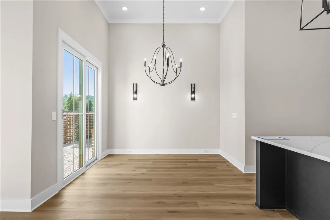 This bright dining area features an elegant chandelier and direct access to an outdoor space.