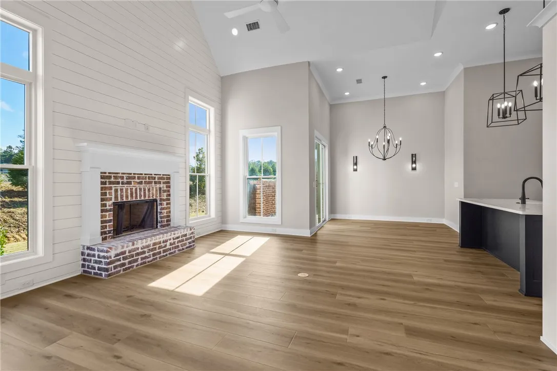 This luminous living space features a cozy fireplace, abundant natural light, and elegant hardwood flooring.