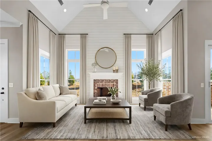 This airy living room features high ceilings and a cozy fireplace, perfect for relaxation and gatherings. (virtually staged)
