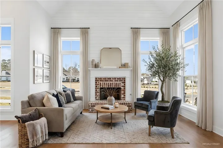 An inviting living room features a fireplace and abundant natural light.