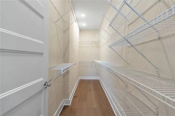 This spacious closet offers ample storage with convenient wire shelving and durable wood flooring.
