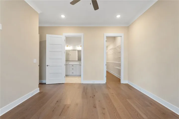 This spacious bedroom offers abundant natural light and seamless access to a well-appointed bathroom and ample closet space.