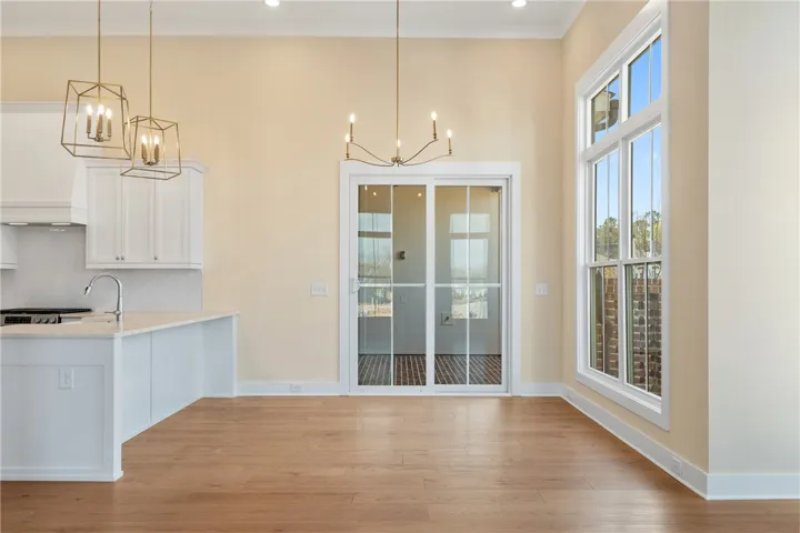 An inviting open-concept area blends kitchen and dining, featuring bright windows and hardwood floors.