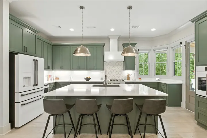 Island comfortably seats 4 and adjoins dining for additional seating. The windows overlook the pool and the door leads to a covered rear porch.
