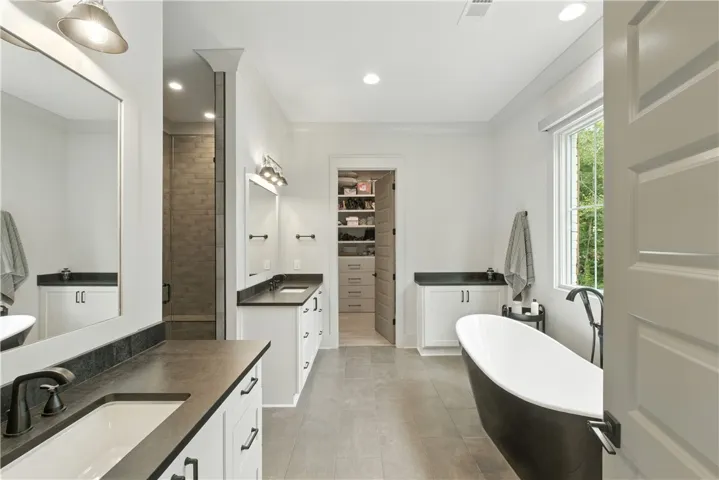 Split Vanities , plenty of additional storage , free standing slipper tub, zero entry tiled shower and an oversized built in , walk in closet