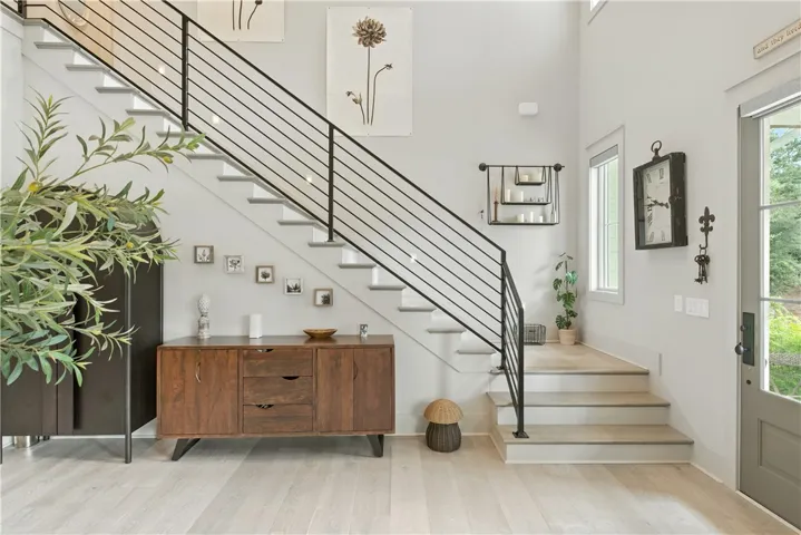 Finished staircase with the metal horizontal stair railing is simply stunning. Notice the high end recessed stairwell lights that have been installed