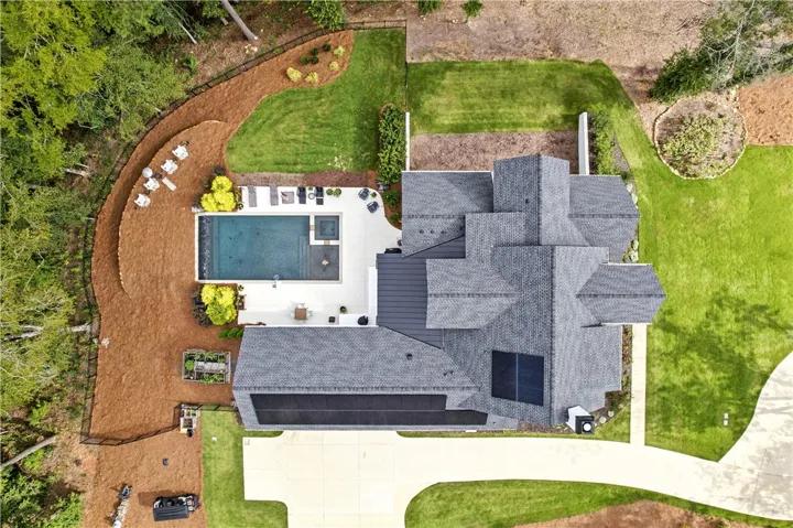 No expense was spared during construction as you can see multiple upgrades in this aerial: Perfectly landscaped,  the rear yard is fully fenced and terraced, the retaining walls are in place, stunning swimming pool & built in hot tub perfectly overlooks Chewacla Creek setting this home apart from the rest. In addition, solar panels are installed over 3 car garage. Electric car hook up in garage if needed.