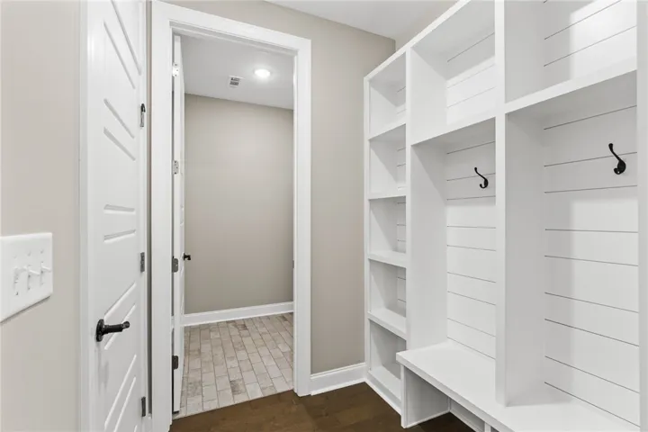 This mudroom offers practical storage solutions with built-in shelving and convenient hooks.