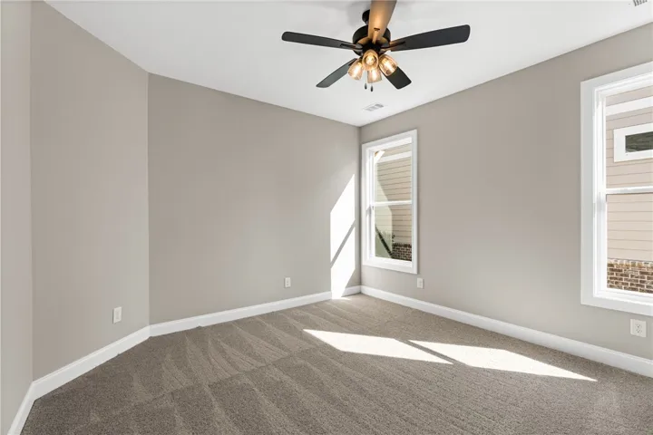 This airy room features abundant natural light and a practical ceiling fan for year-round comfort.
