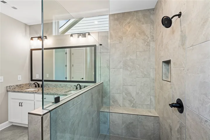 This modern bathroom features a spacious shower and sleek double vanity, creating a serene oasis.