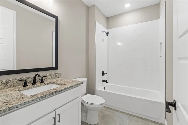 This clean and inviting bathroom features a stylish vanity and a classic tub with modern fixtures.