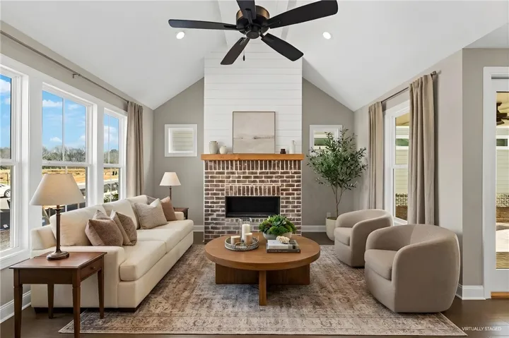 This inviting living area boasts an impressive fireplace and soaring vaulted ceilings, perfect for gatherings.