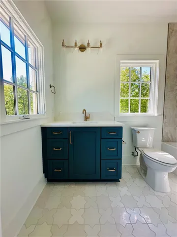 This bathroom features a contemporary vanity and elegant tiled flooring.