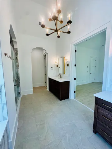 This spacious bathroom offers elegant fixtures and a pristine tiled floor, perfect for serene mornings.