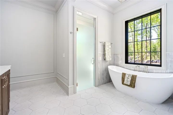 This serene bathroom offers a spa-like escape with natural light and refined finishes.