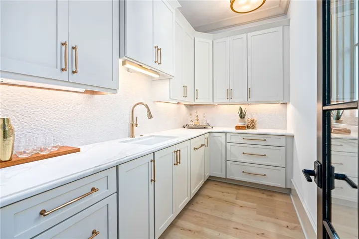 This modern kitchen features crisp cabinetry, gleaming countertops, and bright lighting.
