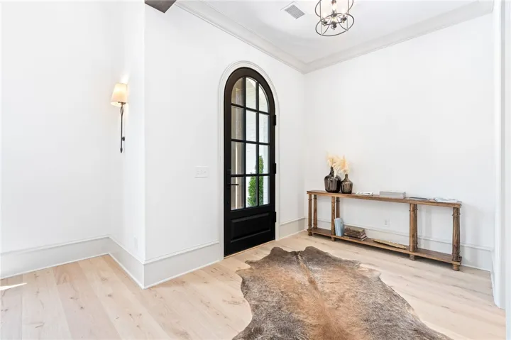 This bright entry offers a welcoming ambiance with its unique door and light flooring.