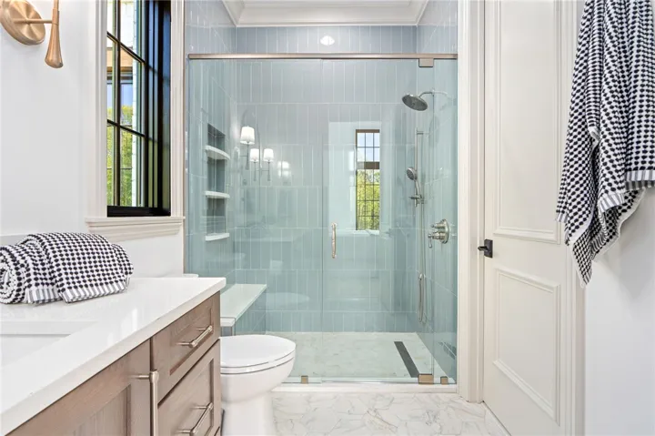 This bathroom features elegant tile work and a spacious shower, blending both functionality and design.