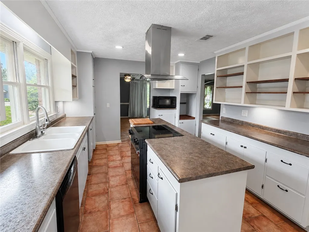 A well-appointed kitchen features a central island, modern appliances, and ample cabinetry with generous counter space.