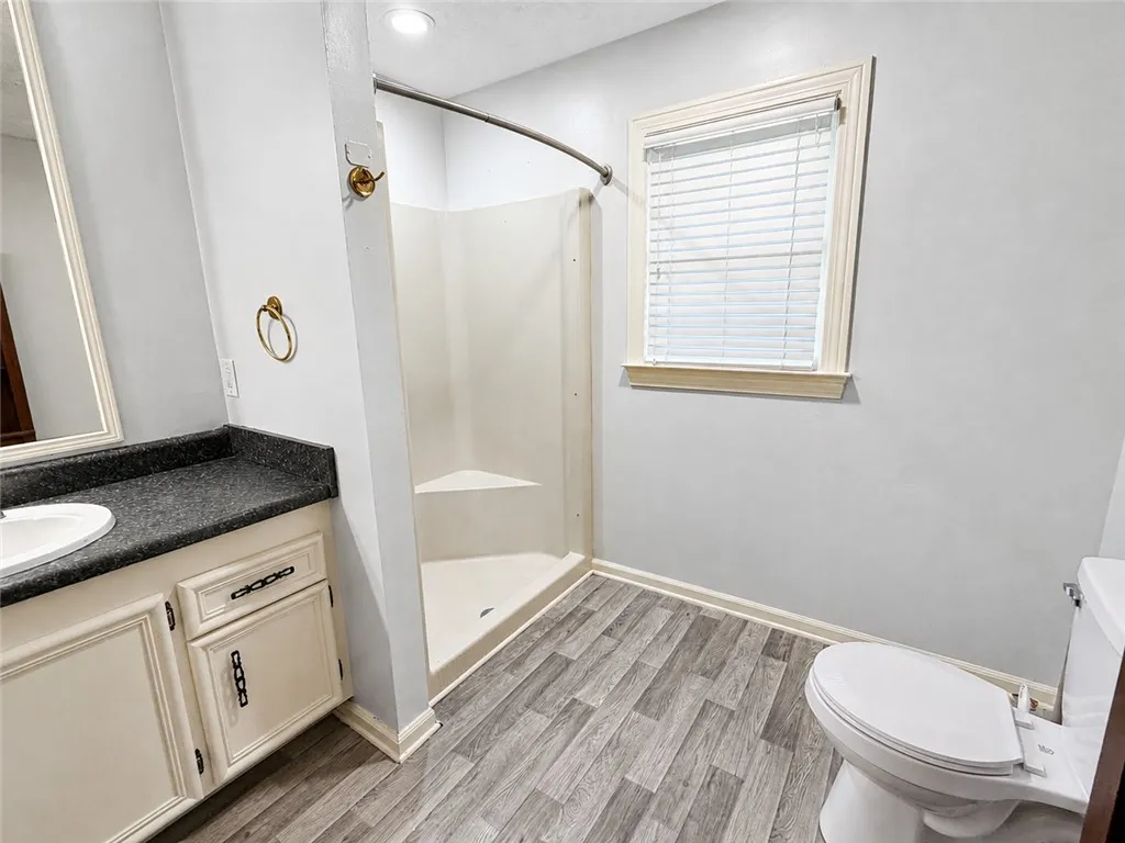Functional full bathroom featuring a stand-up shower and a practical vanity with ample counter space.