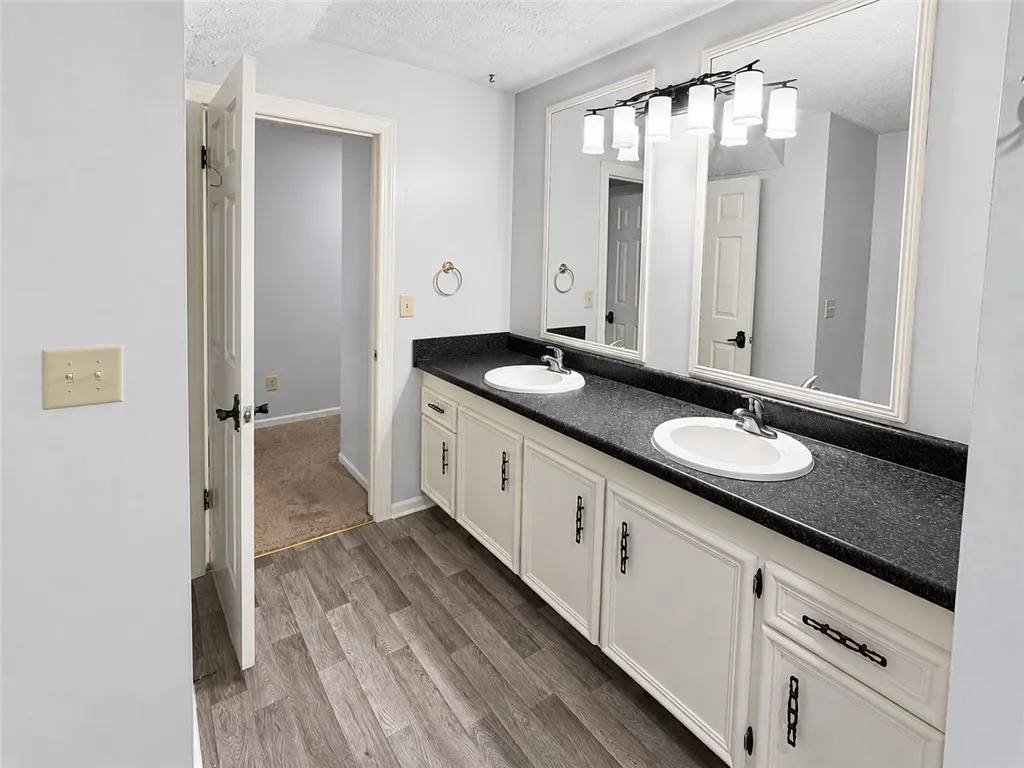 A pristine bathroom features a dual vanity with ample storage and modern lighting.