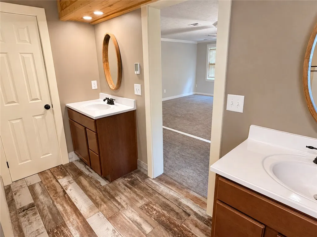 Dual vanity sinks provide ample space in this well-appointed bathroom leading to a private bedroom area.