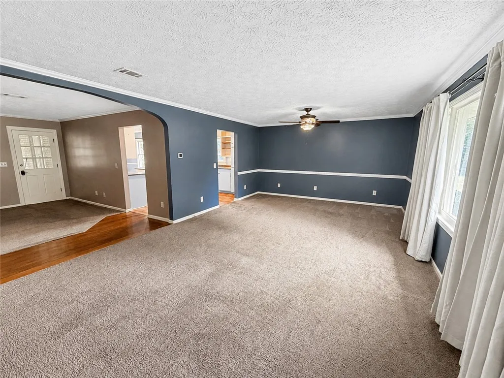 A spacious living area offers comfort with plush carpeting and natural light.