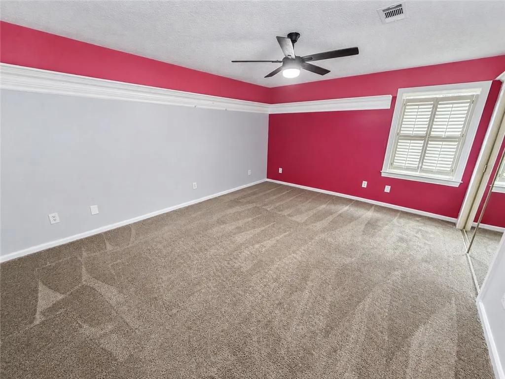 A well-proportioned bedroom with ample natural light offers a comfortable retreat.