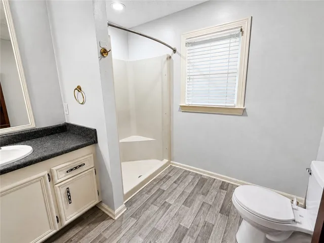 Functional full bathroom featuring a stand-up shower and a practical vanity with ample counter space.