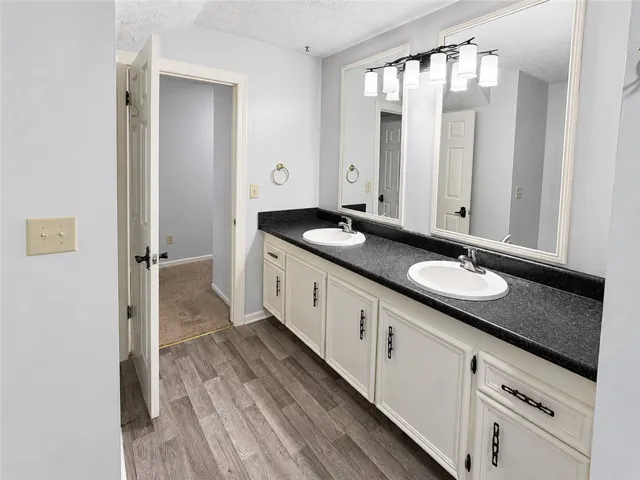 A pristine bathroom features a dual vanity with ample storage and modern lighting.