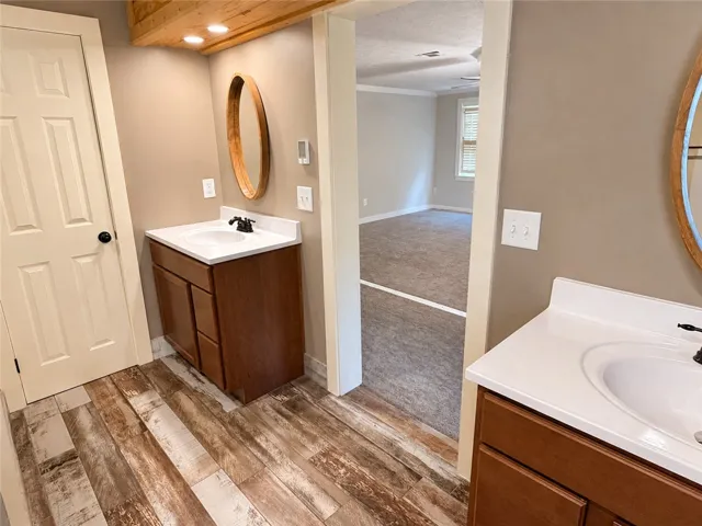 Dual vanity sinks provide ample space in this well-appointed bathroom leading to a private bedroom area.