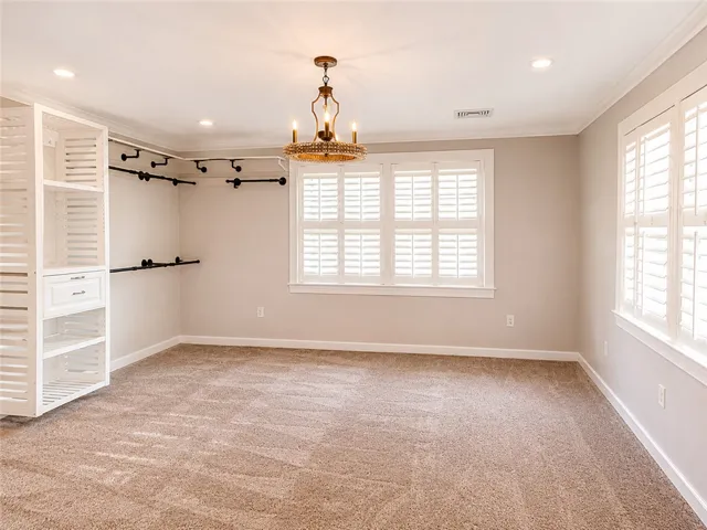 Ample storage and natural light define this well-appointed walk-in closet.