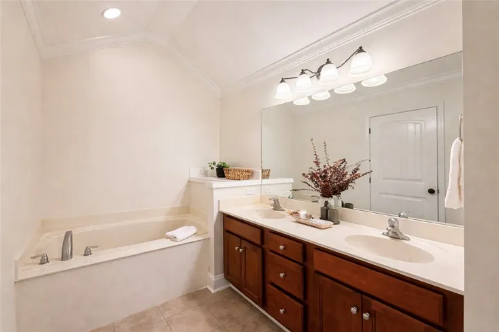 This serene bathroom offers a spacious soaking tub, double vanity, and ample natural light.