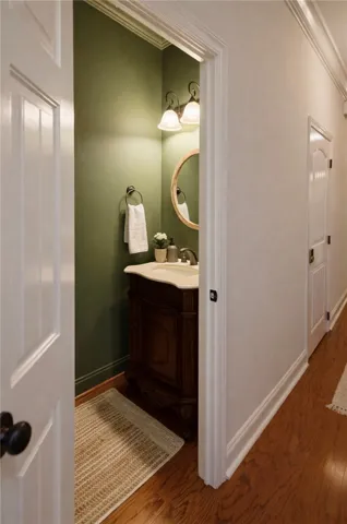 This cozy powder room features a classic vanity and elegant fixtures.