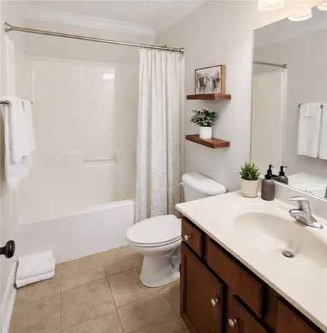 This bathroom features practical design with a combined tub and shower, offering daily comfort.
