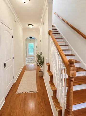 This entry hall features hardwood flooring and a staircase with classic banisters.