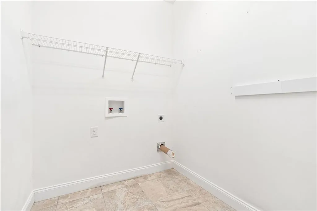 Ready for your washer and dryer, this dedicated laundry space offers convenience and tiled flooring.