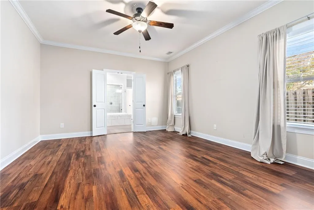Hardwood floors and a ceiling fan create a comfortable ambiance in this restful retreat.