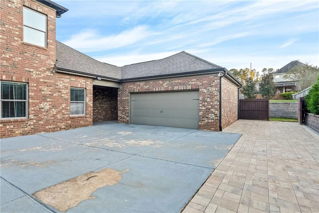 A well-maintained brick exterior showcases ample parking, including a spacious garage and paver driveway.